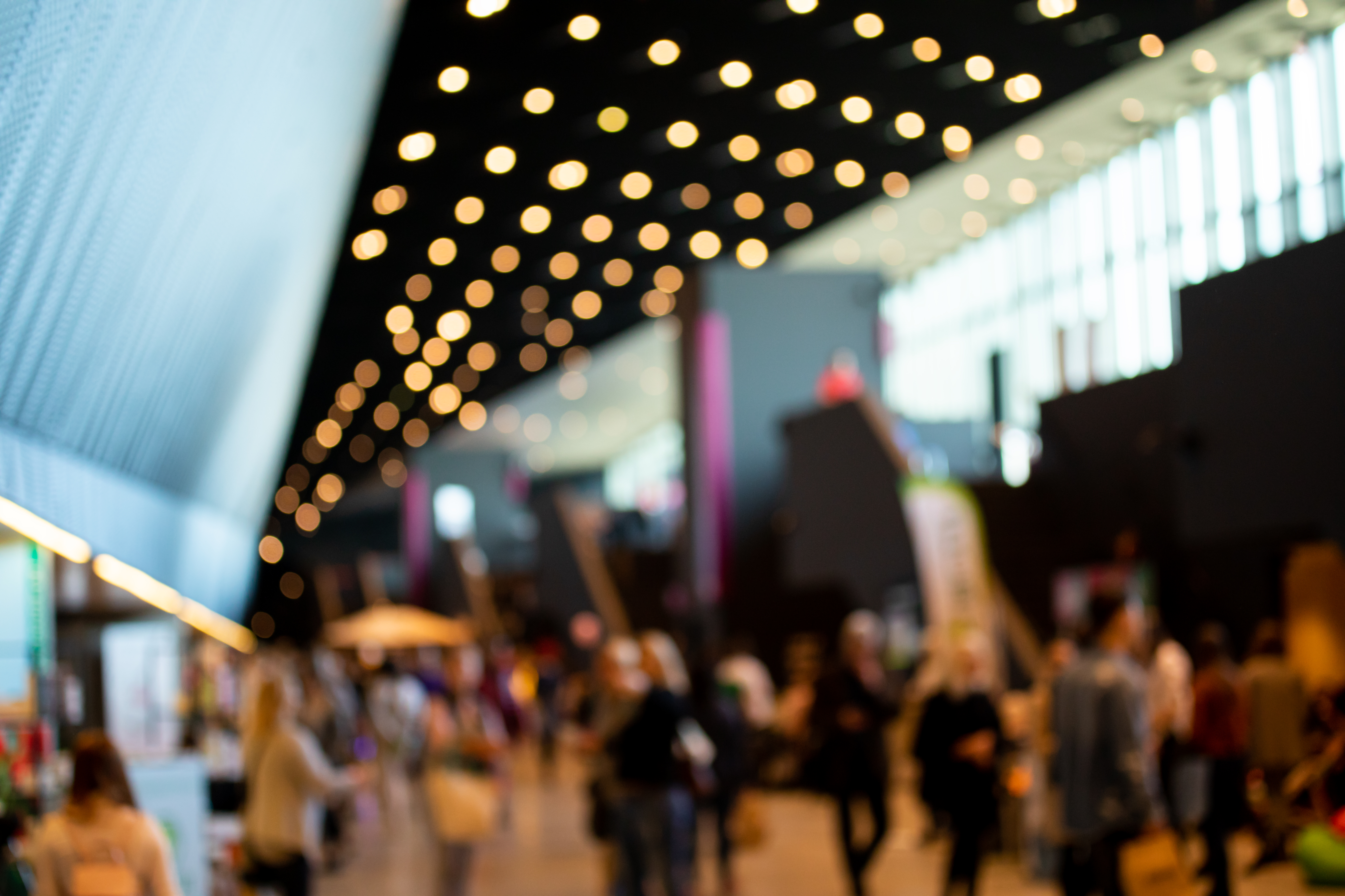 Blurred crowd at Connected Britain 2025 exhibition hall, showcasing networking and telecom innovation discussions.