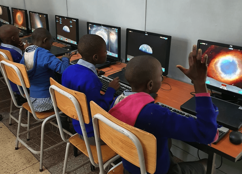 Children sitting in front of computers and doing some tasks