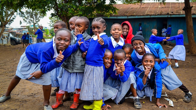 Children in Nairobi sum posing for the picture with smiles and thumb ups