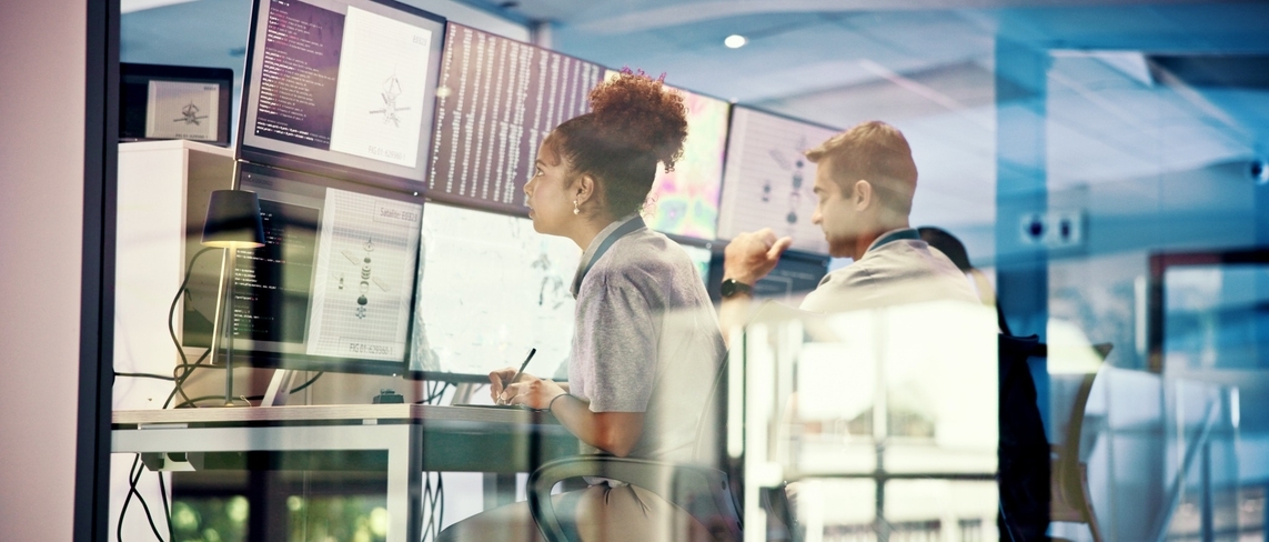 Engineers monitoring multiple data screens in a modern network operations center, representing Vodafone’s Always On Network Monitor solution developed by Sonalake to provide real-time visibility and proactive network management.